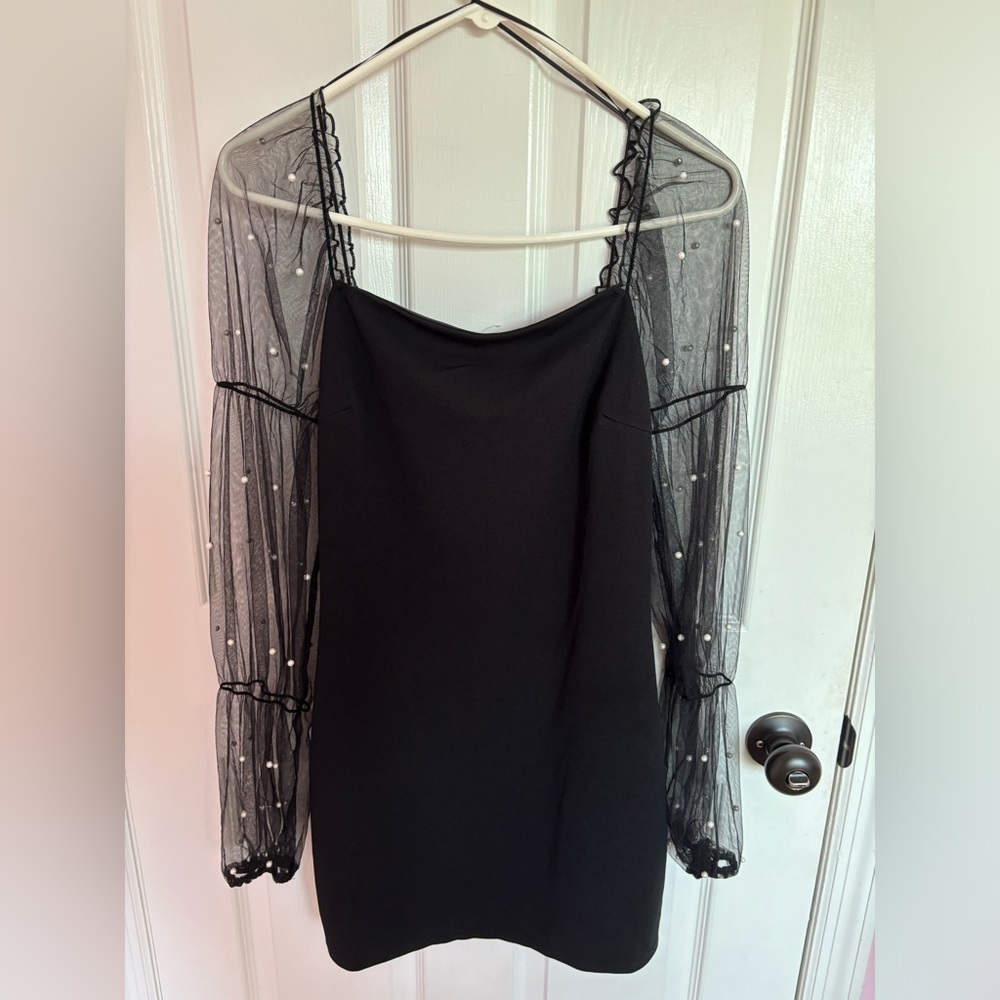 Black mini dress with long mesh sleeves and attached pearls